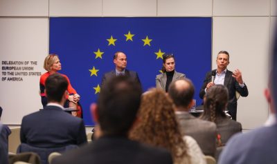 Four men and women sit in front of room during panel discussion.