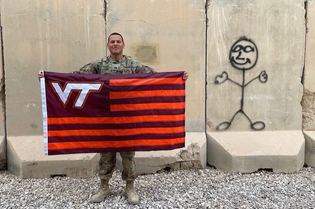 Capt. Chris Lee holds a Virginia Tech flag.