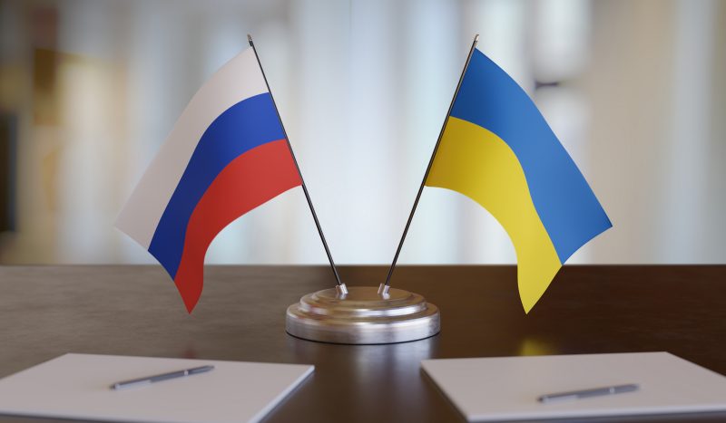 Ukrainian and russian flags on table. 