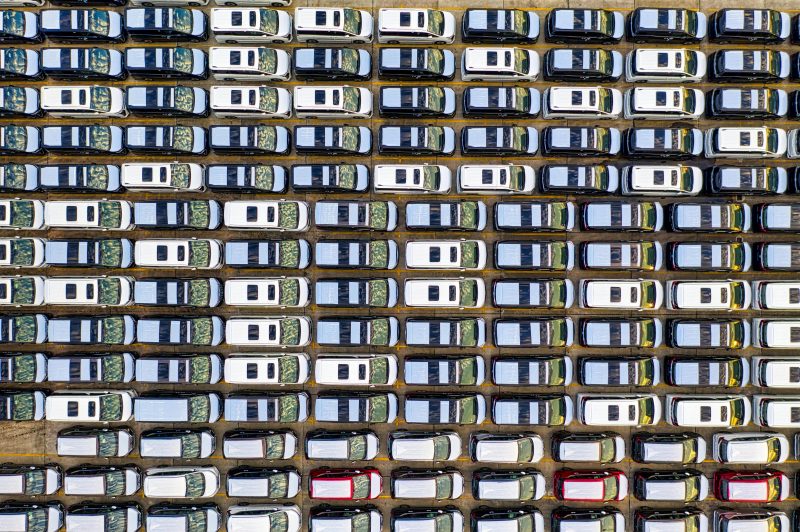 Rows of cars in a lot, seen from above. Image courtesy Pexels.